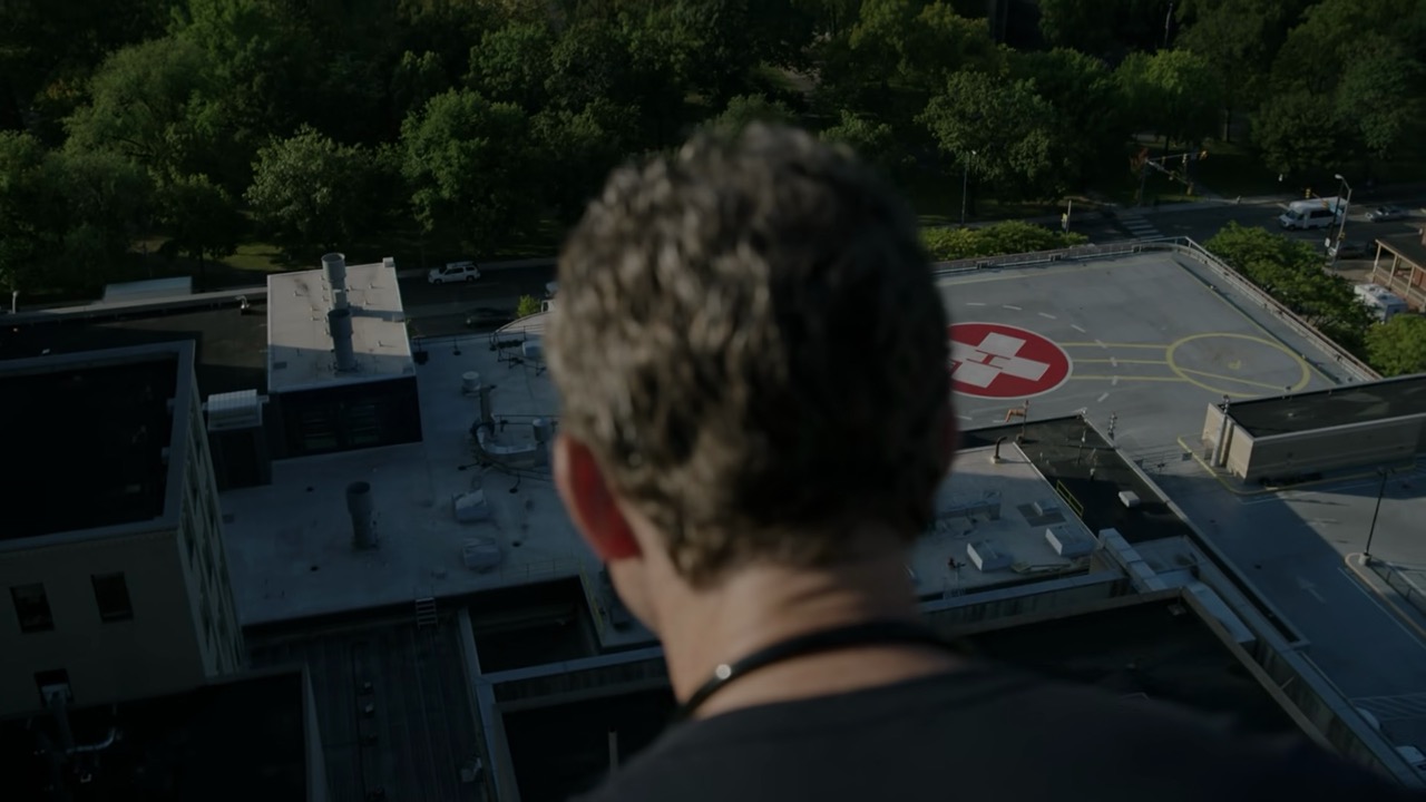 Jack looks off the roof with the hospital helipad in the background